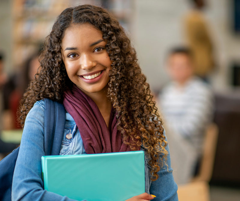 student holding classroom books