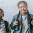 two kids with backpacks on in front of whiteboard